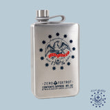 Semiquincentennial 250th Flask made of brushed metal featuring an eagle emblem surrounded by stars and text including "Zero Foxtrot" and "Est. 1776" with a screw cap on a light blue background.
