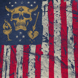 Blackbeard Glory Tee featuring a distressed American flag design with a gold skull wearing horns in place of stars, accompanied by symbols including a torch, broken heart with lightning, and small stars on a dark background.