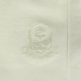 Close-up of sage green fabric with subtle embroidered skull and spade logo detail on the Smuggler French Terry Crew sweatshirt.