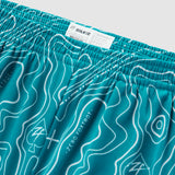 Close-up of teal Topographic Silkies shorts featuring a detailed contour line pattern and an elastic waistband with a sewn-in size label.