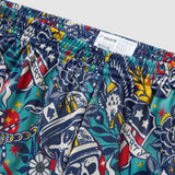 Close-up of colorful patterned fabric featuring skulls, stars, hearts, and banners with the word Liberty on Liberty Skull Silkies shorts with an elastic waistband and size label.