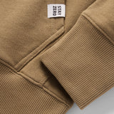 Close-up of the cuff and pocket seam on a brown Smuggler French Terry Crew showcasing the ribbed knit texture and small white brand tag.