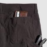 Dark charcoal Field Shorts showing a close-up of the back pocket holding a brown leather wallet and a black multi-tool, highlighting durable fabric and functional design.