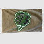 Lucky 13 Flag in tan with red vertical accents and a large green shamrock design featuring Lucky 13 and Zero Foxtrot text, with metal grommets at the corners