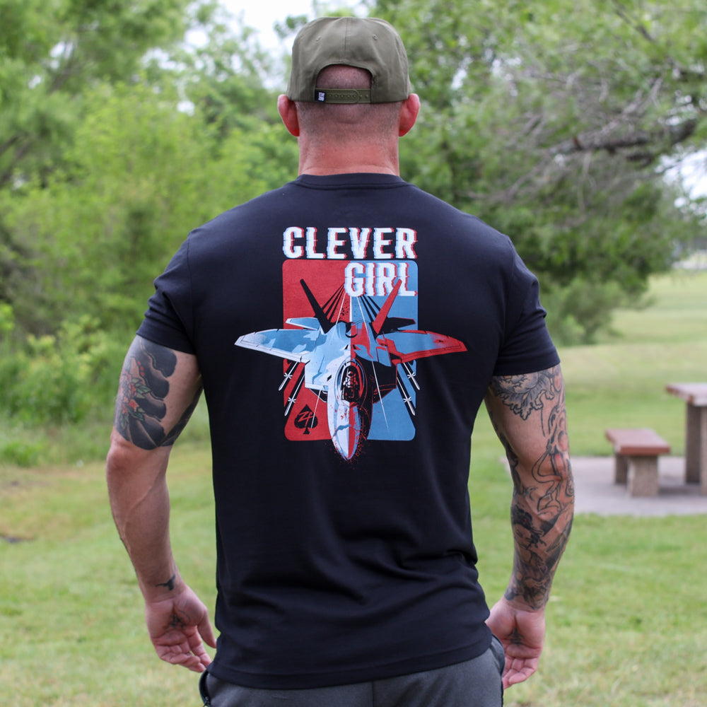 Clever Girl Tee black graphic T-shirt shown from the back on a person outdoors, featuring bold Clever Girl lettering and colorful illustrated design