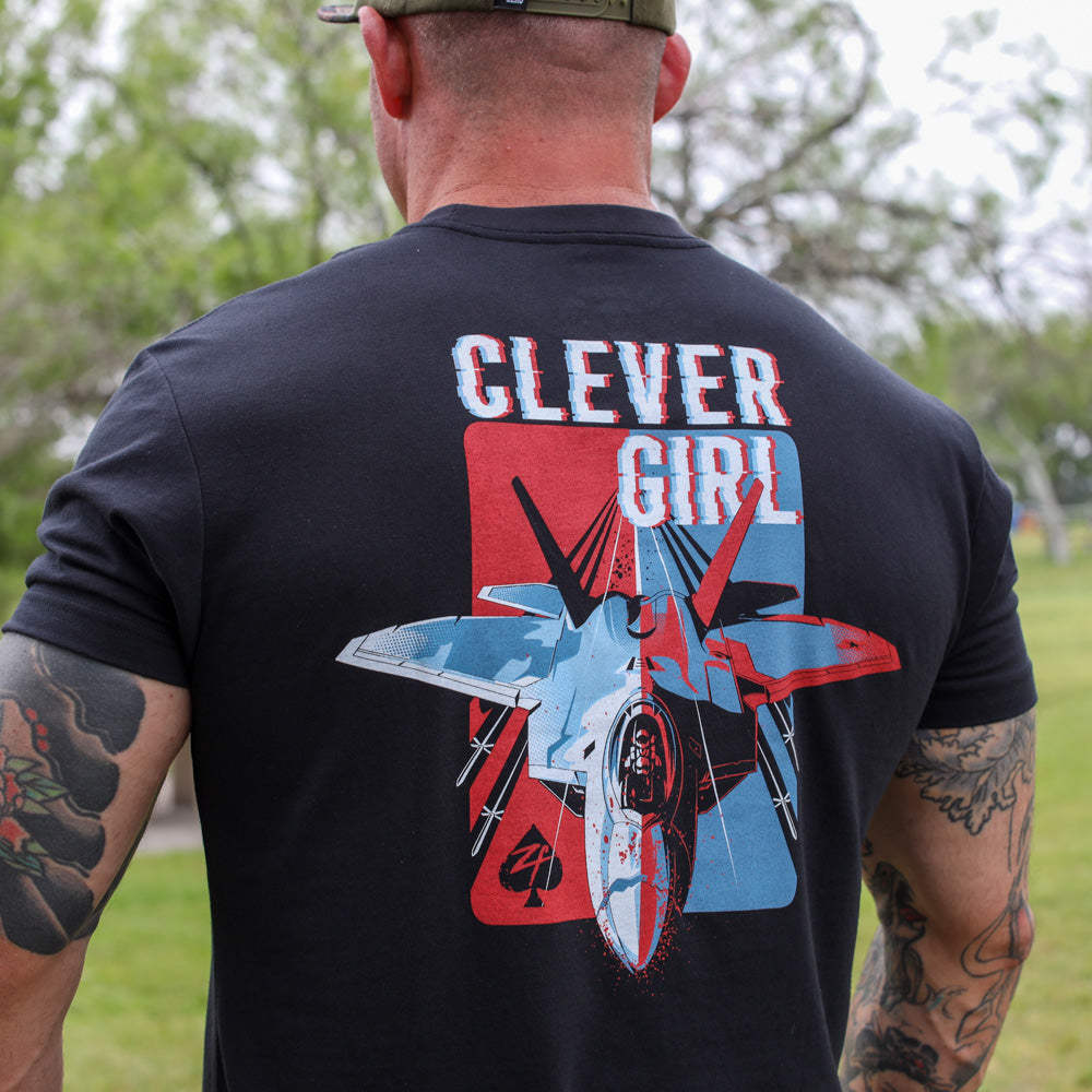 Clever Girl Tee black graphic t shirt shown from the back with bold Clever Girl lettering and a colorful vintage aircraft illustration wearer outdoors