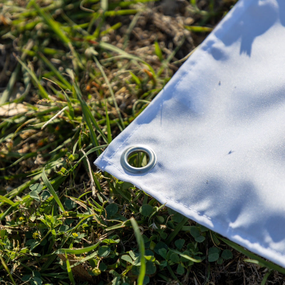 ZF Stars and Stripes Flag corner with a reinforced fabric edge and metal grommet resting on grass outdoors