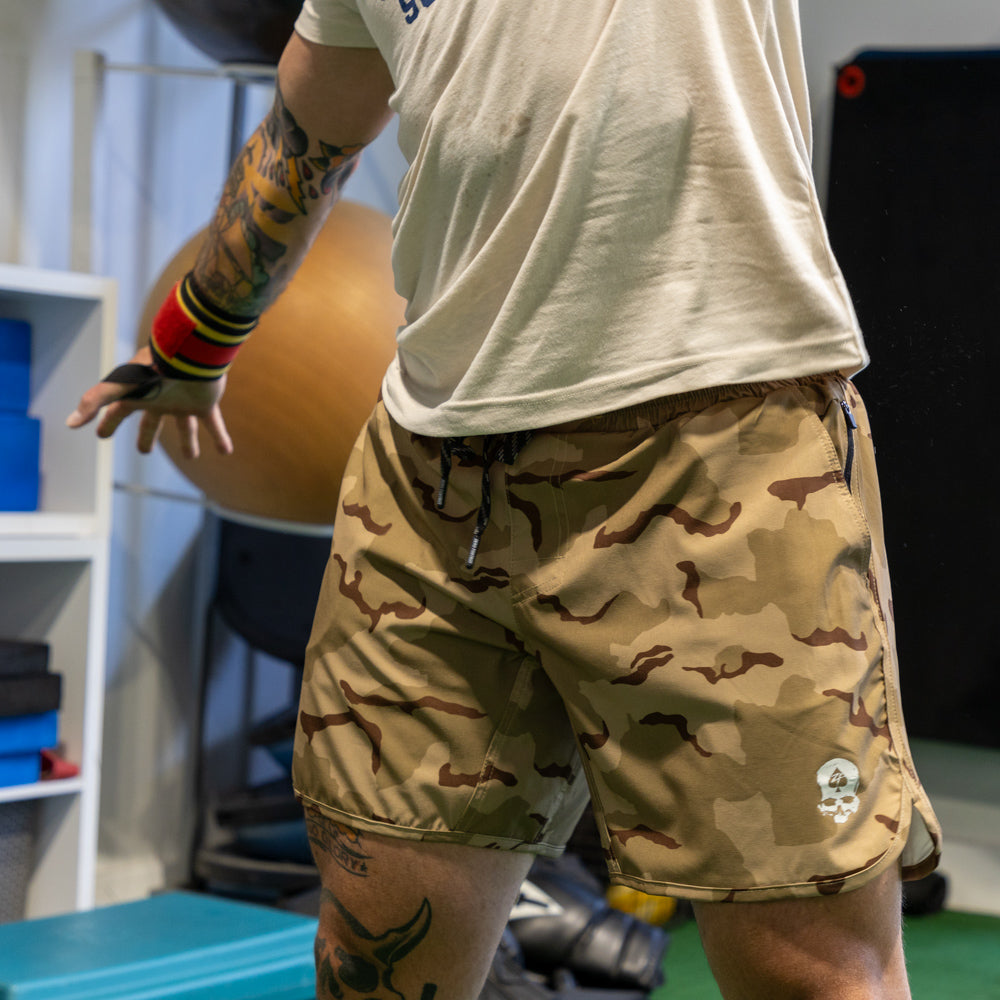 Man wearing camo print Zero Shorts - 7" Inseam with a drawstring waist, in an active workout setting.