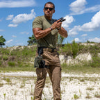 ZF x Kore Sleek Gun Belt worn with a holster by a man holding a handgun outdoors in a sandy landscape under a blue sky