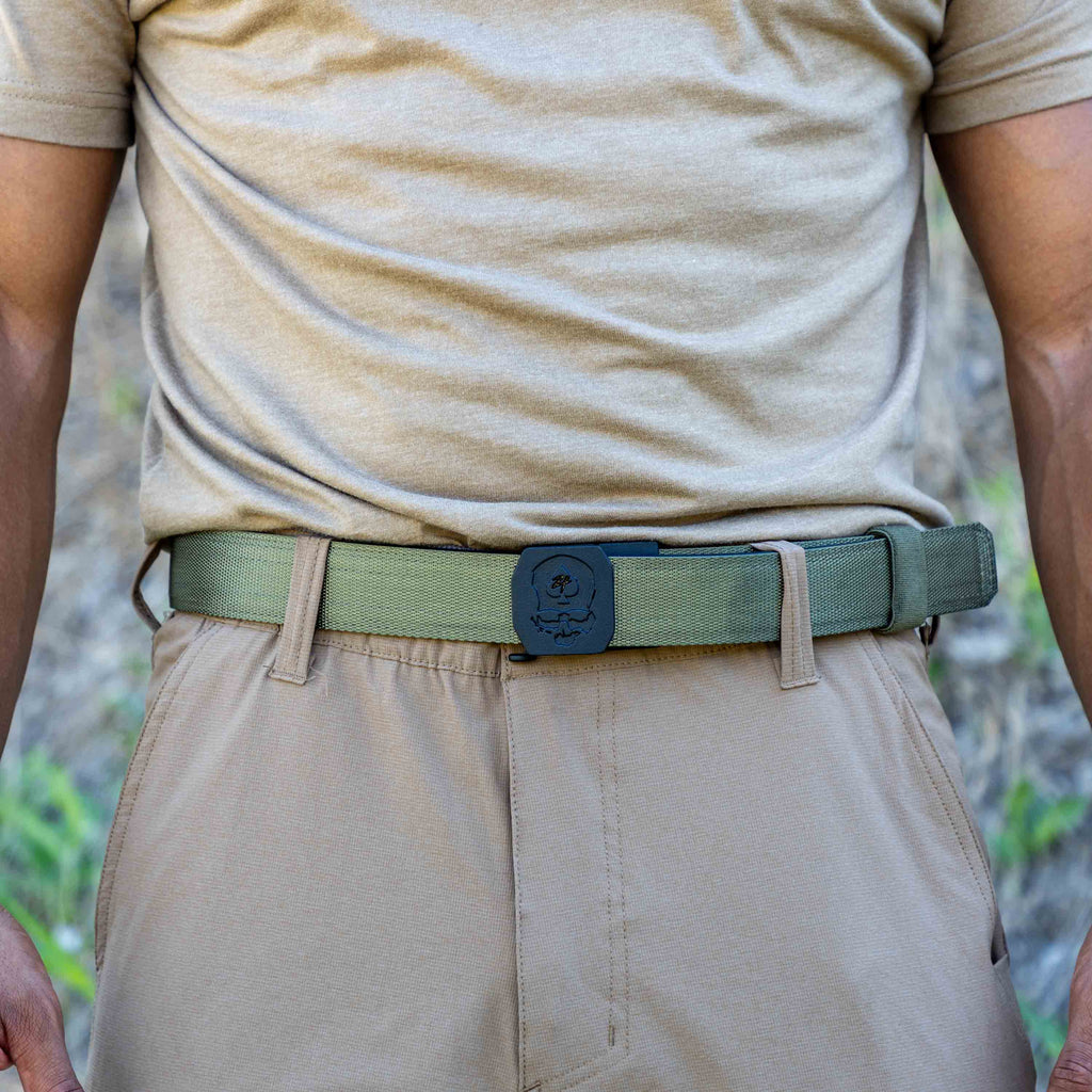 ZF x Kore Sleek Gun Belt in olive green worn with tan pants showing its black central buckle and adjustable webbing strap around the waist