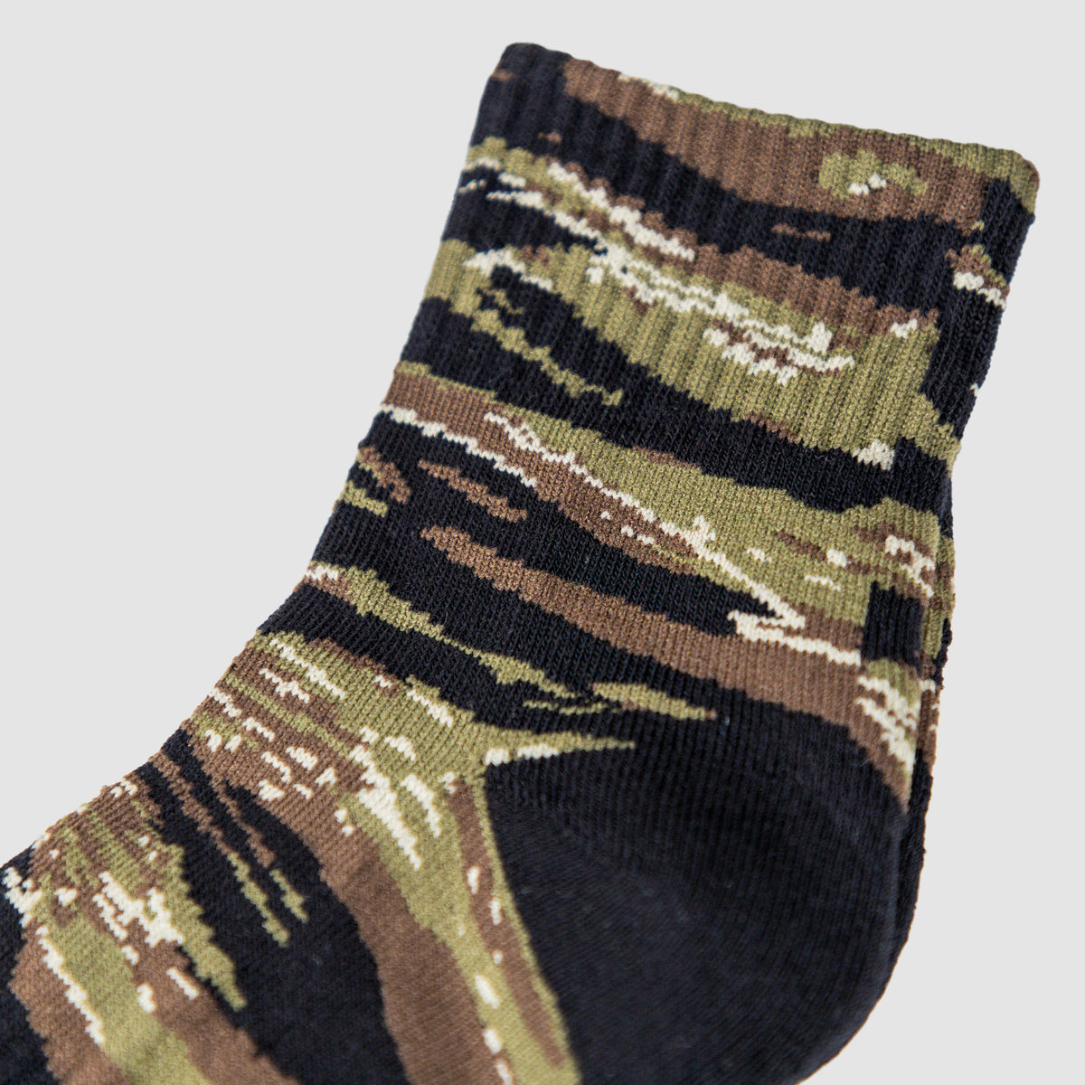 Close-up of a single ankle sock with a tiger jungle camouflage pattern in green, brown, black, and beige colors featuring the product Zero Ankle Socks - Advisor Tiger Jungle and Black.