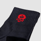 Close-up of a black sock cuff featuring a small red skull design, part of the Zero Ankle Socks - Black Tiger Stripe and Grey collection.