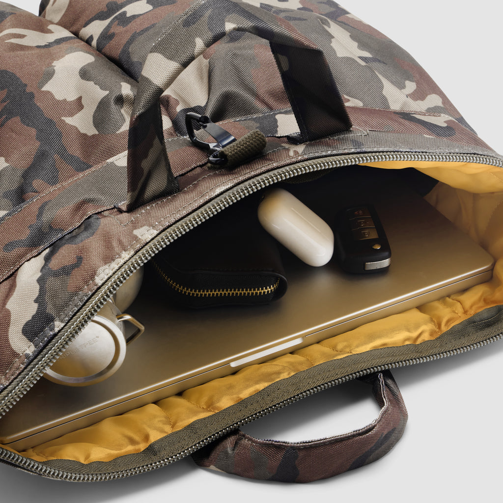 ZF Flyers Helmet Bag in camouflage with padded yellow lining open to show a laptop mouse and small device inside with sturdy carry handles