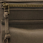 Surplus EDC Sling close up showing textured dark fabric metal zipper and adjustable webbing strap inside the bag