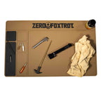 ZF Gun Cleaning Mat in tan color with multiple compartments holding gun cleaning tools including brushes, screwdriver, gun parts, a cloth, and a small bottle.