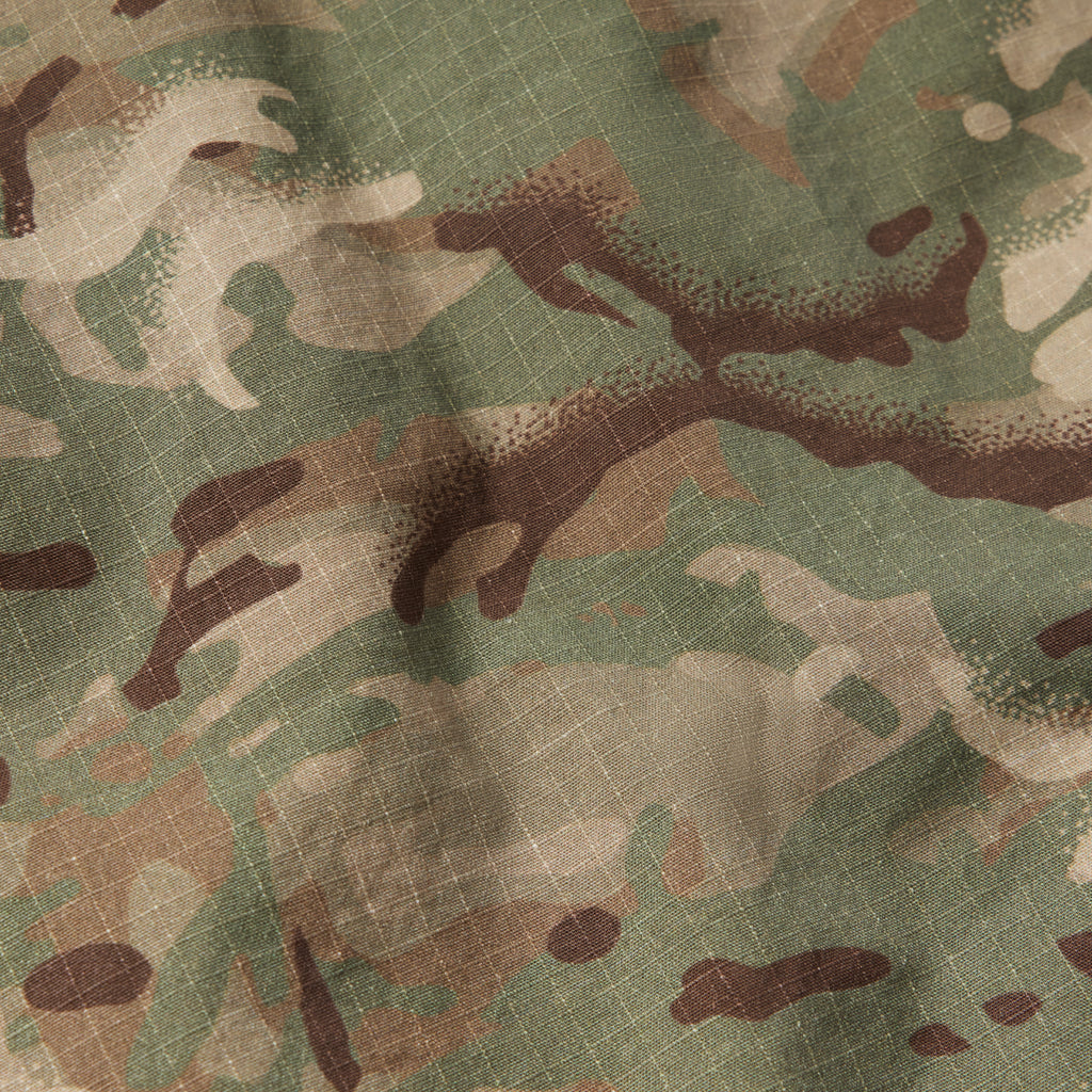 Close-up of fabric with green, brown, and beige camouflage pattern and textured weave, part of the CPO Shirt material.
