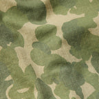 Close-up of green and beige camouflage fabric with a subtle grid pattern, showcasing the texture and material of the CPO Shirt.