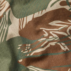 Close-up of fabric in green, brown, and tan brushstroke camouflage pattern with a grid texture detail, part of the CPO Shirt material.