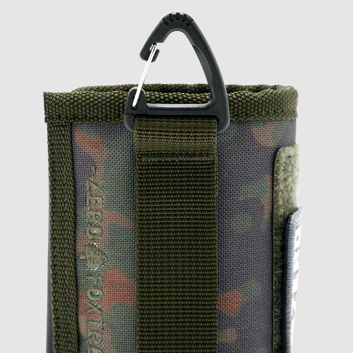 Rations Drink Wrap in camouflage fabric with olive green nylon strap and black plastic carabiner clip attached for easy carrying.