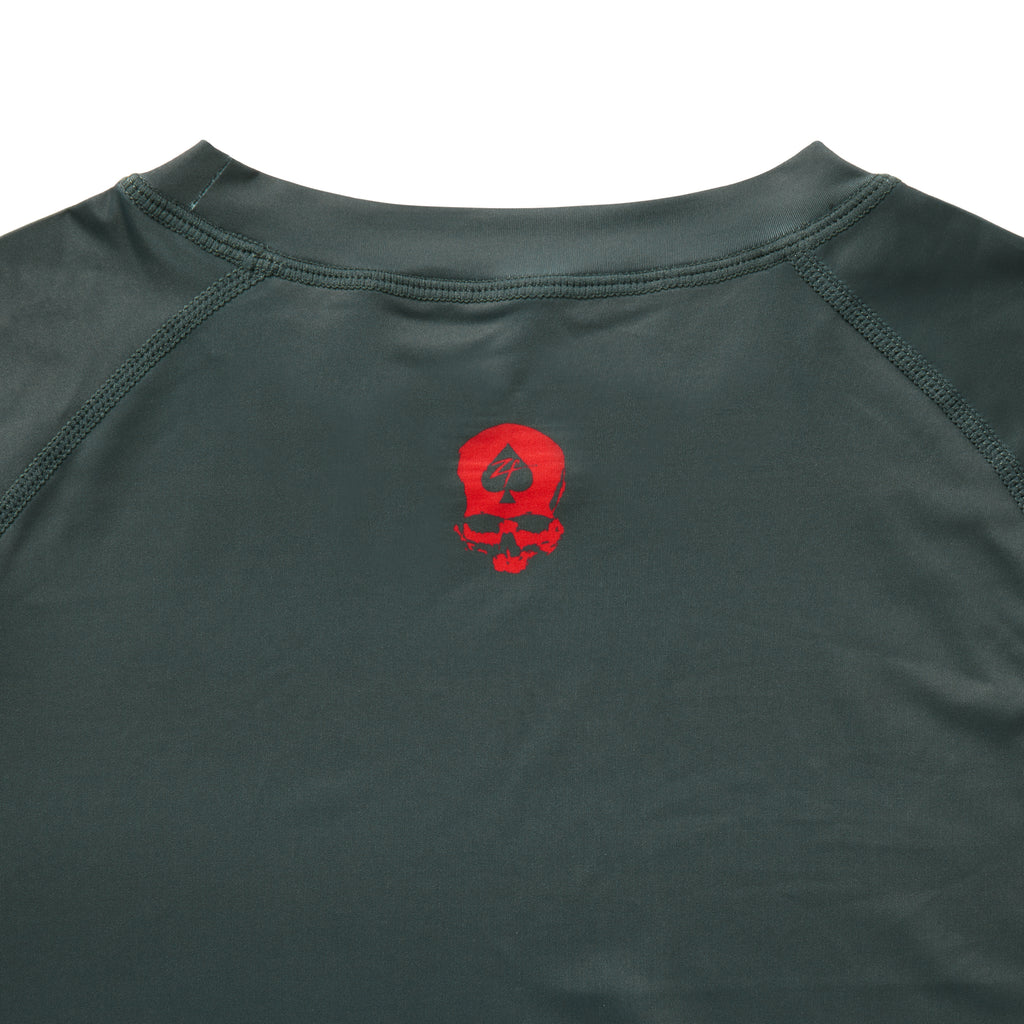 Compression Long Sleeve Rash Guard in dark green with a red skull graphic on the chest crew neckline and raglan sleeve seams