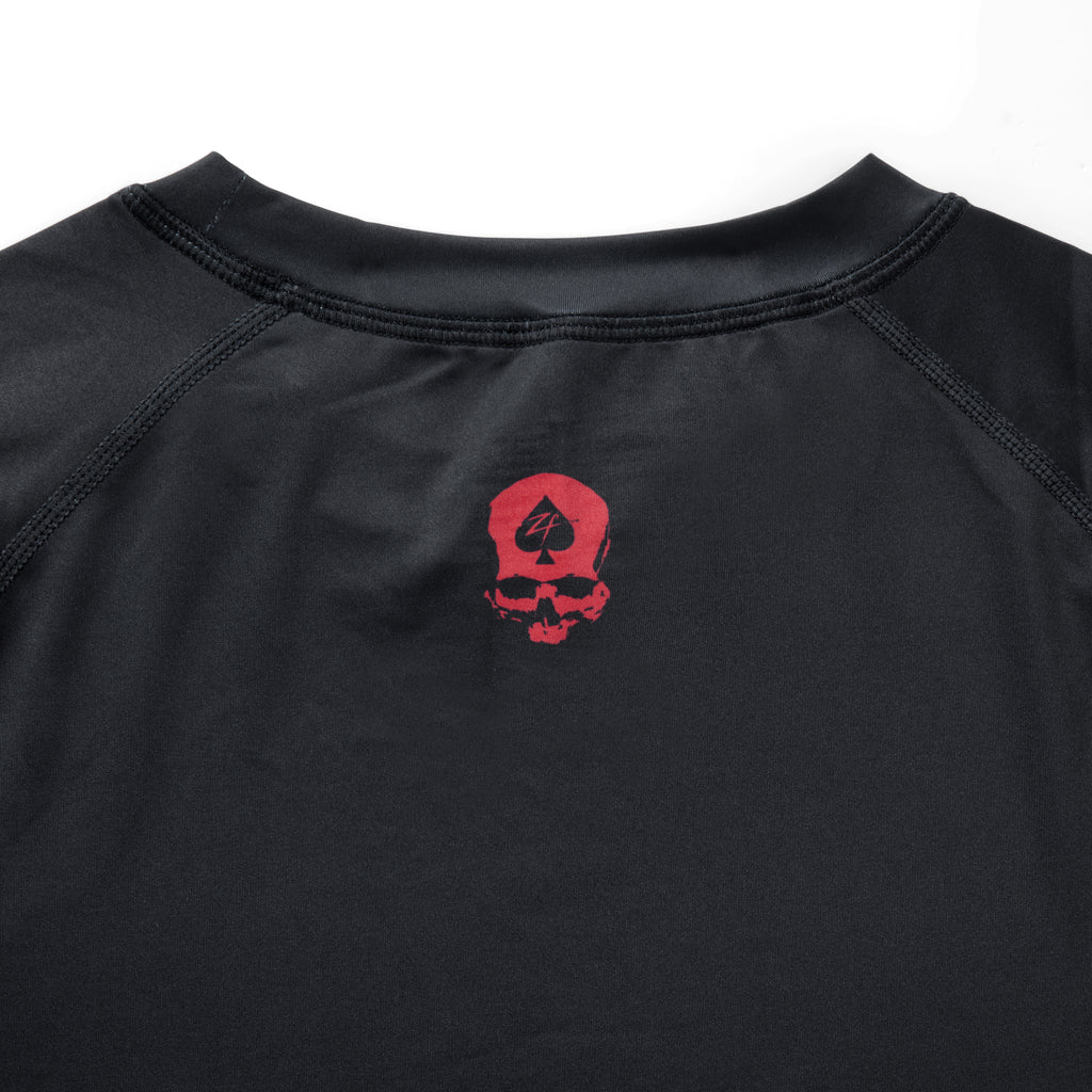 Compression Long Sleeve Rash Guard in black with a crew neckline, stitched seams, and a red skull graphic on the chest”】【