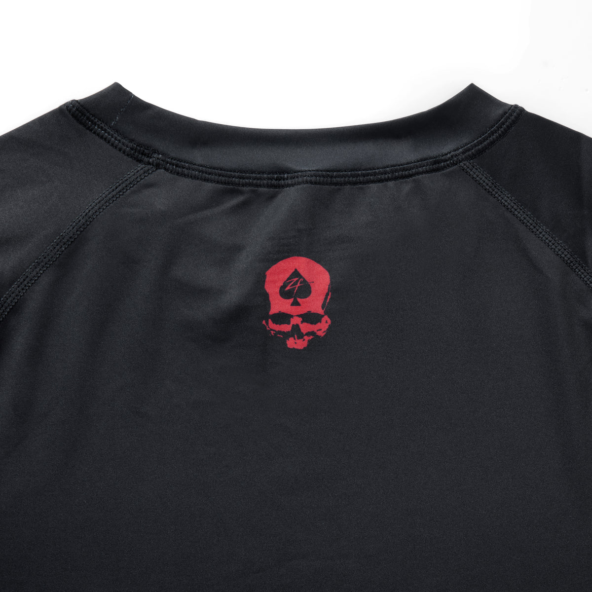 Compression Long Sleeve Rash Guard in black with a crew neckline, stitched seams, and a red skull graphic on the chest”】【
