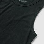 Close-up of a black Skivvy Tank made from ribbed cotton fabric, showcasing its sleeveless design and round neckline on a flat surface.