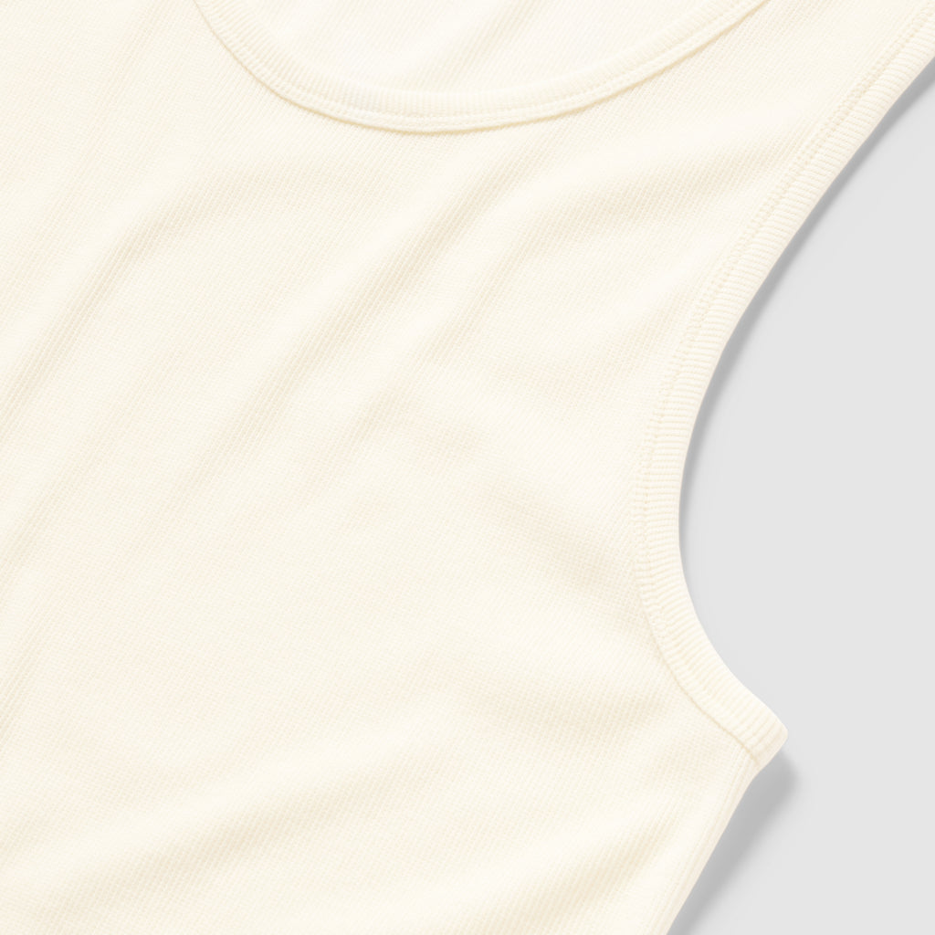 Close-up of a soft, white ribbed cotton Skivvy Tank showing its sleeveless design and rounded neckline on a light background.