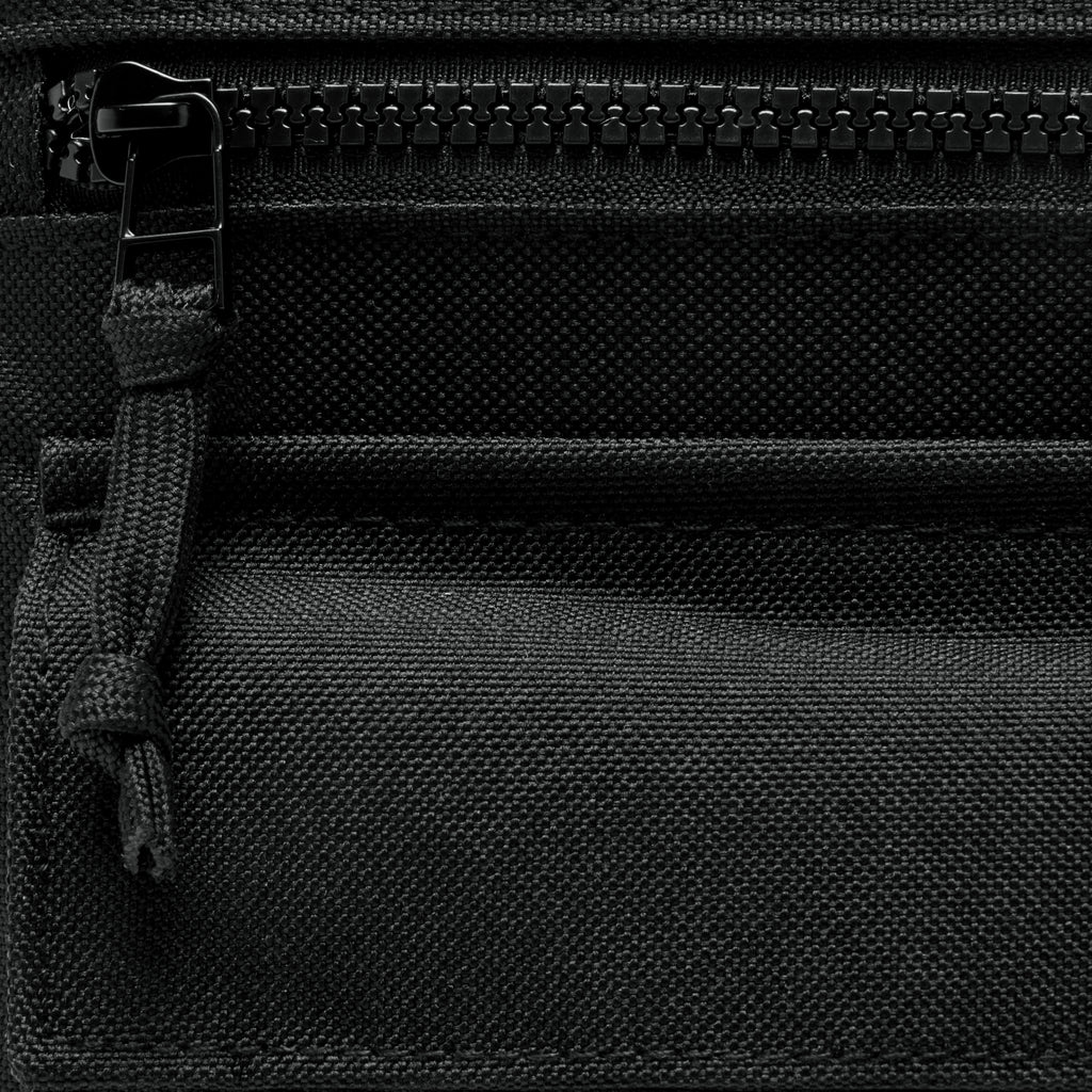 Surplus EDC Sling close up showing black woven fabric, front zippered pocket, and adjustable strap detail