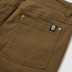 Foxhole 5 Pocket Pant in brown with a detailed rear patch pocket, double stitching, metal rivets, belt loops, and skull logo label