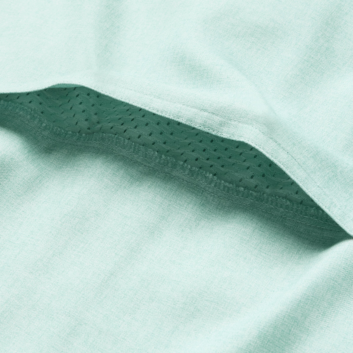Close-up of the aqua-colored breathable mesh fabric detail under the hem of the F'n Soft Daily Shirt, highlighting its soft and lightweight material construction.