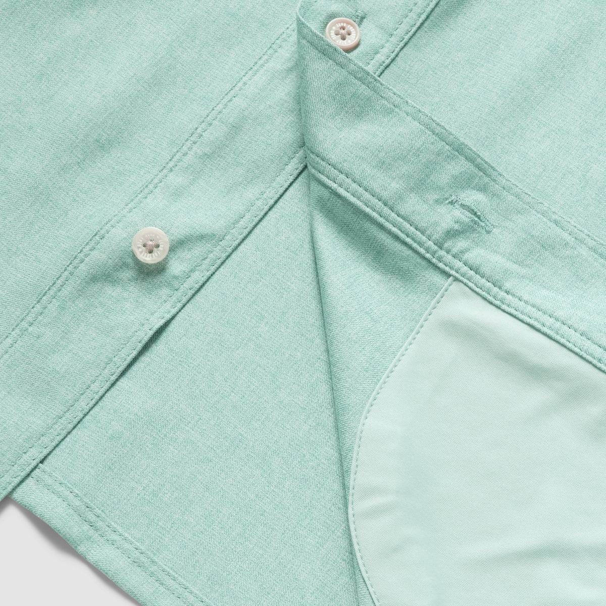 Close-up of aqua fabric with button detail and inner pocket lining on the F'n Soft Daily Shirt, showcasing soft texture and quality stitching.