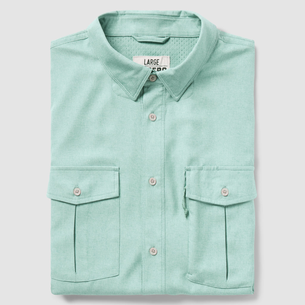 Folded aqua-colored button-up shirt with two front flap pockets and a classic collar, displayed against a light background, identified as the F'n Soft Daily Shirt.