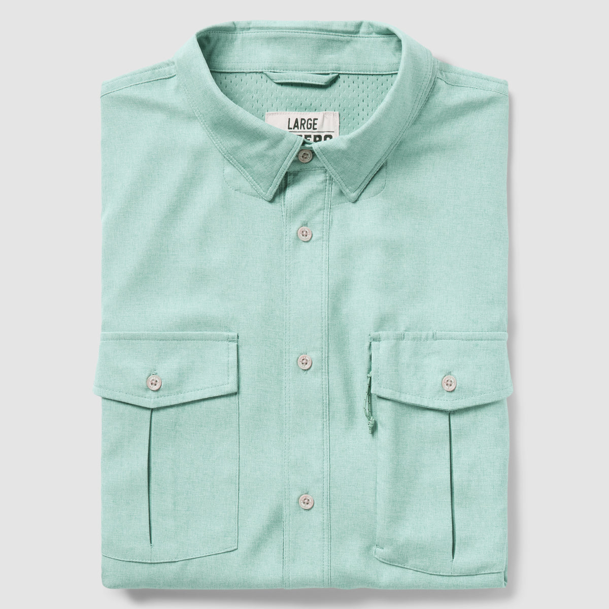 Folded aqua-colored button-up shirt with two front flap pockets and a classic collar, displayed against a light background, identified as the F'n Soft Daily Shirt.