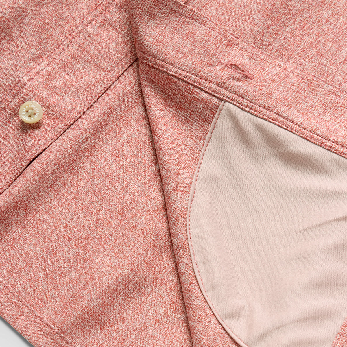 Close-up of the rust-colored fabric and button details of the F'n Soft Daily Shirt, highlighting the textured material and inner lining stitching.