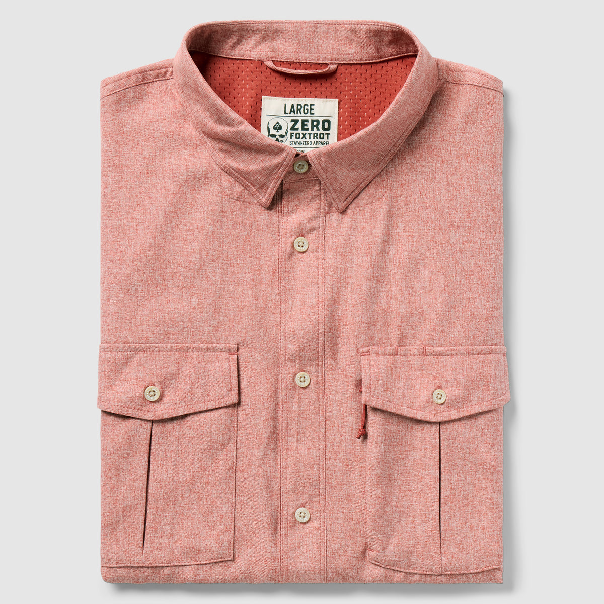 Folded rust-colored button-up shirt with two front flap pockets and a collar, labeled as F'n Soft Daily Shirt in size large.