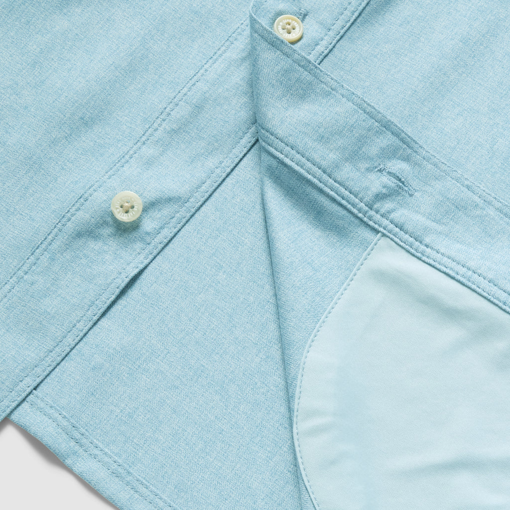 Close-up of a light blue button-up shirt showing cream-colored buttons and the soft inner lining of the F'n Soft Daily Shirt.