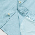 Close-up of a light blue button-up shirt showing cream-colored buttons and the soft inner lining of the F'n Soft Daily Shirt.
