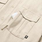 F'n Soft Daily Shirt in beige with button front and flap chest pocket, shown in close-up with a small black label