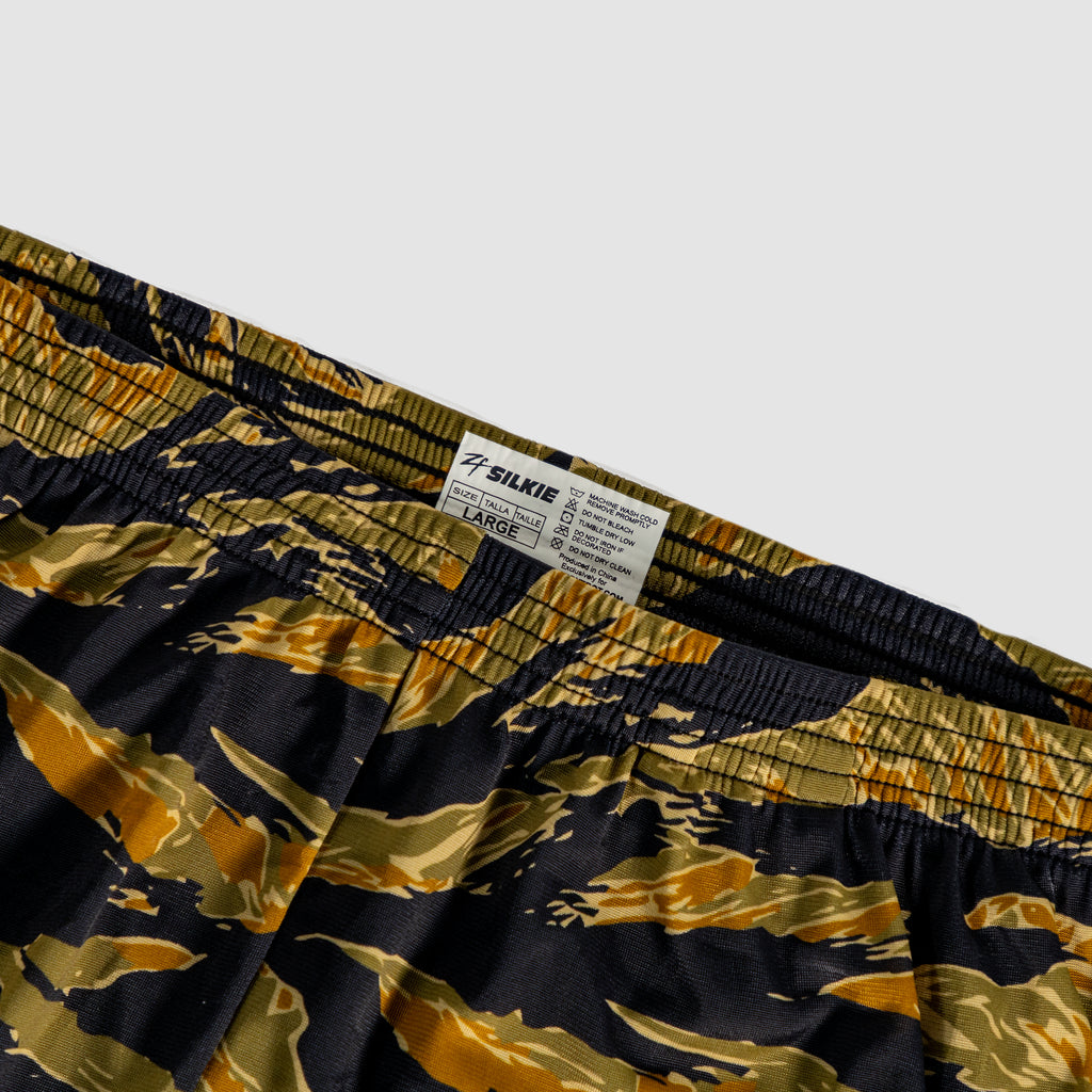 Close-up of camo-patterned elastic waistband with label on ZF Silkies - Camos shorts, featuring green, brown, and black shades in a tiger stripe design.