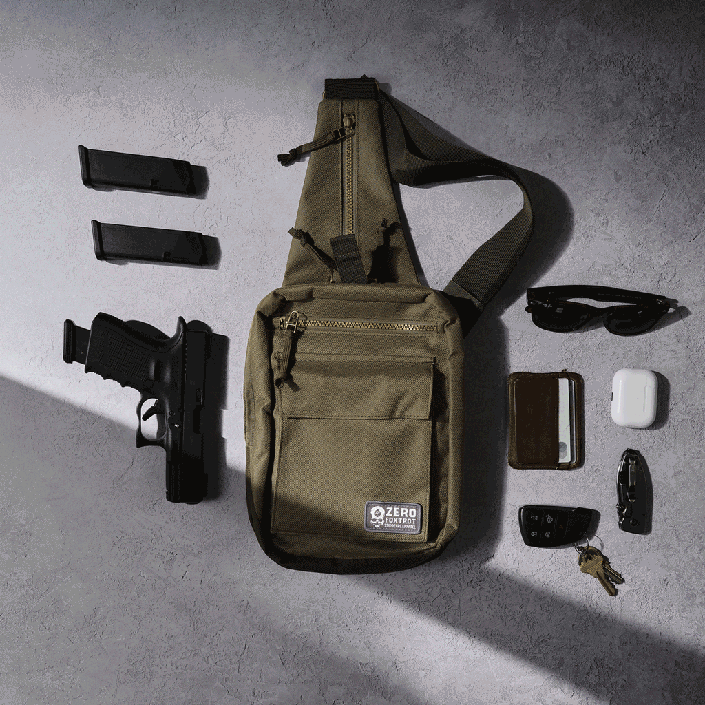 Surplus EDC Sling olive green crossbody bag displayed with adjustable strap, front pockets, handgun, magazines, sunglasses, phone, earbuds case, knife, and keys