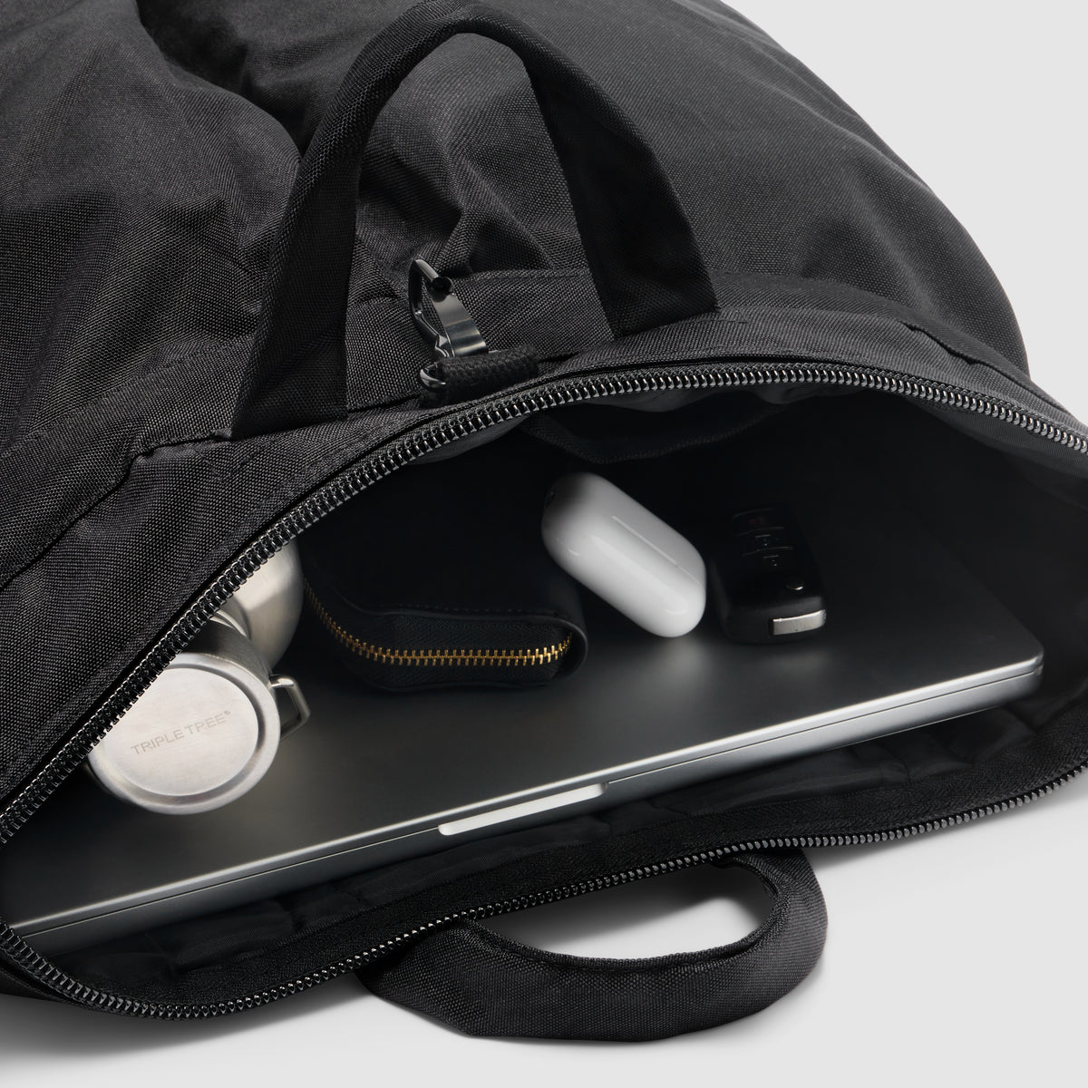 ZF Flyers Helmet Bag in black, shown open with a laptop, wireless earbuds, case, and accessories inside, featuring zippered compartments and carry handles