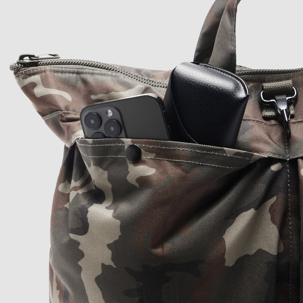 ZF Flyers Helmet Bag close-up in camouflage fabric with a smartphone and black case stored in its front pocket