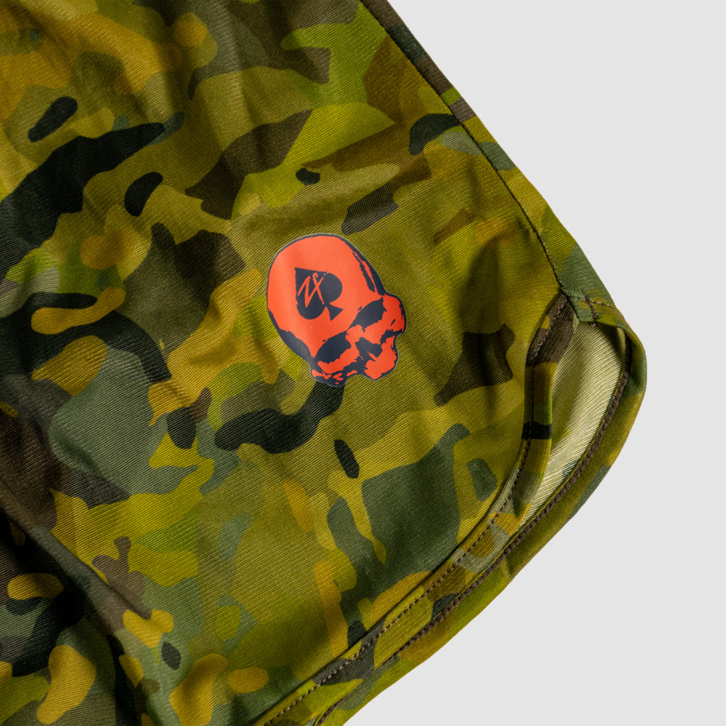 Close-up of camo patterned fabric with green and brown tones featuring a bright red skull logo detail on the edge of a garment titled ZF Silkies - Camos.