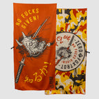 Orange and camo patterned microfiber beach towel (2025) featuring bold graphic designs with a fierce demon face and katana sword, and text saying "No Fucks Given!" in English and Japanese.