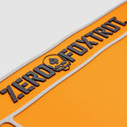 Close-up of the orange ZF Gun Cleaning Mat featuring raised black lettering and a skull logo on a textured surface designed for firearm maintenance.