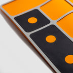 Close-up of the corner of a ZF Gun Cleaning Mat featuring an orange and black grid pattern designed for organized firearm maintenance and cleaning.