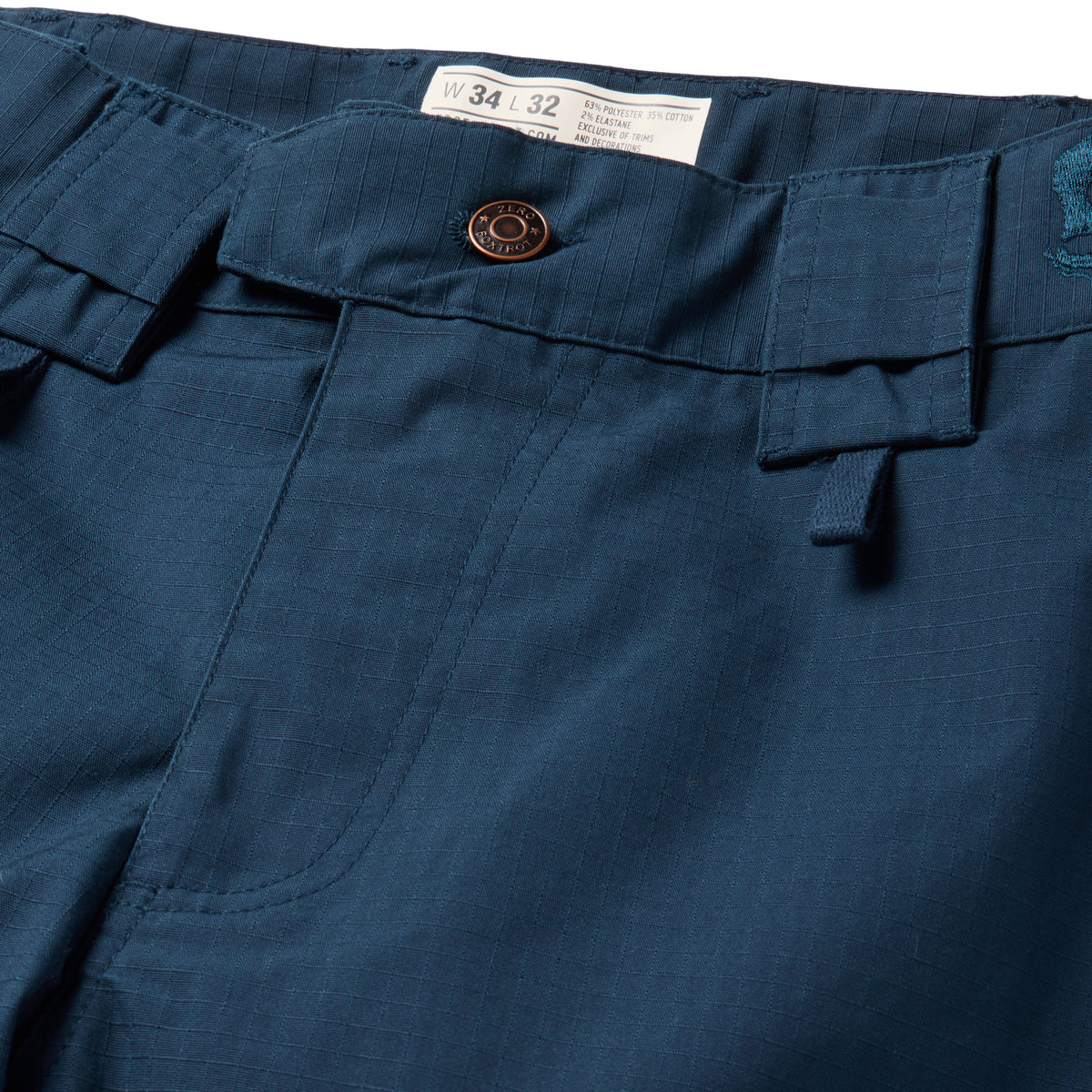 Tac Pants in dark navy with button closure belt loops cargo pockets stitched seams and a visible W34 L32 size label close up