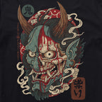 Close-up of a detailed graphic featuring a traditional Japanese demon mask with large horns, sharp teeth, and blood-like red accents on a black fabric, printed on the ONI Tatari Tee.