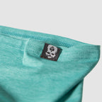 Close-up of ocean blue fabric with a skull and spade logo tag on a Performance Sun Gaiter showing detailed stitching and soft material texture.